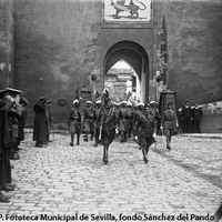 Puerta del León. Desfile de las Fuerzas Regulares Indígenas, creadas en Marruecos en 1911. En el interior, aún perduran las edificaciones que tapiaban los arcos y parte del lienzo de muralla. 1920-1922 ©ICAS-SAHP. Fototeca Municipal de Sevilla, fondo Sánchez del Pando