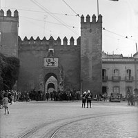 Puerta del León del Alcázar coronada con la bandera tricolor de la Segunda República. Guardias de Asalto escoltan la entrada ante la expectación del público asistente al acto de la entrega oficial del Real Alcázar al Ayuntamiento de Sevilla. 31 de octubre de 1931 ©ICAS-SAHP. Fototeca Municipal de Sevilla, fondo Sánchez del Pando