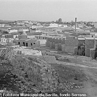 Construcción de la barriada de los Toreros. Almacén de aceitunas, chimenea de la fábrica de aceites refinados de Idogra, -donde actualmente está el Parque Centro- y fábrica harinera La Modelo. 1961 ca. ©ICAS-SAHP, Fototeca Municipal de Sevilla, fondo Serrano