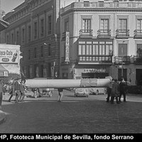 Traslado a pie hasta la Catedral del cuadro Proclamación del dogma de la Inmaculada, obra de Alfonso Grosso, desde el palacio de Dueñas. Aledaña al Palacio de Justicia, la farmacia de San Pedro. Marzo de 1966. ©ICAS- SAHP, Fototeca Municipal de Sevilla, fondo Serrano