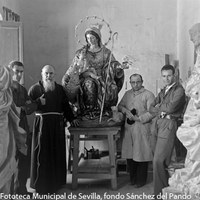 22.- Taller del escultor Sebastián Santos Rojas posando junto al padre capuchino Ardales ante la imagen de la Divina Pastora encargada para el convento de la Inmaculada de Antequera (Málaga). En la fotografía se aprecia también la Inmaculada de la parroquia de San Sebastián de Sevilla y la Virgen del Reposo de Valverde del Camino (Huelva). 1940. ©ICAS-SAHP, Fototeca Municipal de Sevilla, fondo Sánchez del Pando