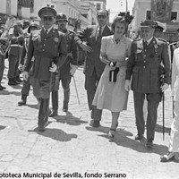 Llegada de Eva Duarte al barrio de la Macarena. Revista de tropas junto al Arco acompañada de las autoridades locales y el ministro de Justicia. A la izquierda el fotógrafo Cecilio Sánchez del Pando inmortaliza el momento con su cámara de placas. ©ICAS-SAHP, Fototeca Municipal de Sevilla, fondo Serrano