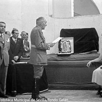 El hermano mayor de la Hermandad de la Macarena Francisco Bohórquez dirige unas palabras de bienvenida y le hace entrega de una fotografía de la Virgen con marco de plata. ©ICAS-SAHP, Fototeca Municipal de Sevilla, fondo Gelán