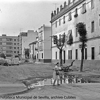 8. Barriada Retiro Obrero. Calle [Gumersindo Azcárate] en mal estado de pavimentación. Al fondo, la calle [Palma del Río]. Levantada sobre la antigua Huerta de la Pintada entre 1927-1935, responde a la idea de ciudad-jardín. 1972 ©ICAS-SAHP, Fototeca Municipal de Sevilla, archivo Cubiles