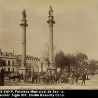 Niños y mayores se agrupan ante la presencia del fotógrafo bajo las columnas romanas procedentes de la calle Mármoles y  coronadas con las estatuas de Hércules y Julio César, obra de Diego de Pesquera. [1880-1905] ©ICAS-SAHP, Fototeca Municipal de Sevilla, Colección Siglo XIX. Emilio Beauchy Cano.
