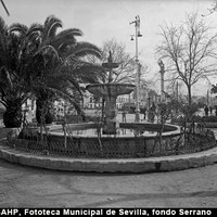 La fuente de la Pila del Pato en el extremo norte de la Alameda. Al fondo, las columnas con leones del siglo XVIII conocidos como Hércules Nuevos. Hacia 1930 esta zona se denomina Plazuela de la Pileta del Pato. Fue colocada en 1881 procedente de la plaza de San Francisco y trasladada al Prado de San Sebastián en 1942. ©ICAS-SAHP, Fototeca Municipal de Sevilla, fondo Serrano
