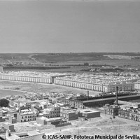 06. Vista del barrio de San Gonzalo y barrio Voluntad, Ca.1958. La barriada de San Gonzalo, conocida como El Tardón y situada en terrenos de la huerta de El Aceitero, se construye en 1952 en respuesta al aumento de población procedente de la inmigración rural y a la necesidad de reubicar a los vecinos desalojados a causa de la modernización y reurbanización del centro histórico.   ©ICAS-SAHP. Fototeca Municipal de Sevilla, fondo Serrano
