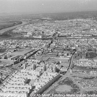 08. Vista aérea de la barriada San Gonzalo y Barrio Máquinas, 1962. Magnífica vista de la otra Triana donde se aprecian sus límites geográficos: la plaza de San Martín de Porres con su sempiterno Autódromo León y la calle López de Gomara. Las cocheras de los tranvías taponan lo que desde 1992 es la Ronda de Triana.  ©ICAS-SAHP. Fototeca Municipal de Sevilla, fondo Serrano