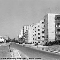 15. Calle López de Gomara, Ca.1970. Rotulada en 1955, la calle López de Gomara, es la vía que limita con la antigua Triana. A la derecha el grupo de viviendas de cuatro plantas pertenecientes al Barrio Voluntad. A la izquierda, ya construido, el Instituto Gustavo Adolfo Bécquer y el Colegio Elena Canel.  ©ICAS-SAHP. Fototeca Municipal de Sevilla, fondo Serafín