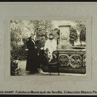 Fiesta de carnaval en el colegio de los Escolapios. El pequeño “Pierrot” posa junto a sus padres en la fuente del patio central. 1914-1915. ©ICAS-SAHP, Fototeca Municipal de Sevilla, Colección Blanco Picabía