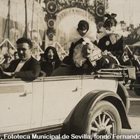 Automóvil con un grupo disfrazado de “Pierrot”. El recorrido del paseo comenzaba en la avenida de Venezuela, actual Reina Mercedes, y seguía por la avenida Reina Victoria, actual de la Palmera. Al fondo se aprecia la entrada al Parque de Atracciones de la Exposición Iberoamericana. 2 de marzo de 1930 ©ICAS-SAHP, Fototeca Municipal de Sevilla, fondo Fernando Carmona