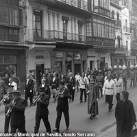 Desfile de la Corporación Municipal y del gobernador civil por la actual avenida de la Constitución camino de la catedral. Precede el paso de la comitiva la Banda de Música Municipal y cierra la Policía Local con uniforme de gala. 1965 ©ICAS-SAHP, Fototeca Municipal de Sevilla, fondo Serrano