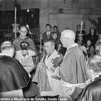 El gobernador civil Alfonso Orti Meléndez-Valdés en el momento de recibir la Espada de San Fernando en presencia del teniente alcalde Santiago Garrigós, que porta el Pendón del santo rey. En este acto en la Capilla Real se jura el pleito-homenaje donde los portadores prometen devolver los enseres sin daño alguno. 1956 ©ICAS-SAHP, Fototeca Municipal de Sevilla, fondo Gelán