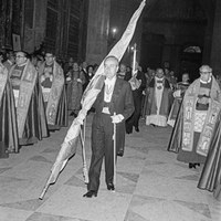El teniente de alcalde José Jesús García Díaz llevando el Pendón delante del gobernador civil Luis Fernández, que sostiene en sus manos la espada Lobera. Tras un paréntesis en el año anterior, los participantes volvieron a vestir de etiqueta. 1978 ©ICAS-SAHP, Fototeca Municipal de Sevilla, fondo Gelán