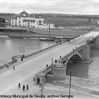 Vista del puente de San Telmo recién inaugurado, el ex convento de Los Remedios y algunas fábricas en los aledaños. Destaca el cartel de la inmobiliaria Los Remedios, S.A. en la plaza de Cuba sin urbanizar. 1931 ©ICAS-SAHP, Fototeca Municipal de Sevilla, archivo Serrano