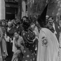Nazareno de la Hermandad de la Macarena besando a un niño en brazos de su madre la mañana del Viernes Santo. 1934-1936 ©ICAS-SAHP, Fototeca Municipal de Sevilla, fondo Serrano