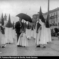 Salida procesional de la hermandad de San Benito. Niño nazareno resguardado de la lluvia con un paraguas. En 1936, la hermandad tuvo que regresar a su templo a causa de la lluvia. 1936 ©ICAS-SAHP, Fototeca Municipal de Sevilla, fondo Serrano