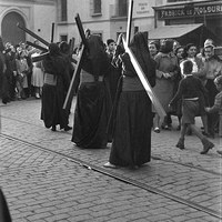 Penitentes de la Hermandad de los Estudiantes de la Iglesia de la Anunciación. El Cristo de la Buena Muerte a punto de girar por la calle Orfila junto al edificio del colegio de Villasís. 1950 ©ICAS-SAHP, Fototeca Municipal de Sevilla, fondo Serrano
